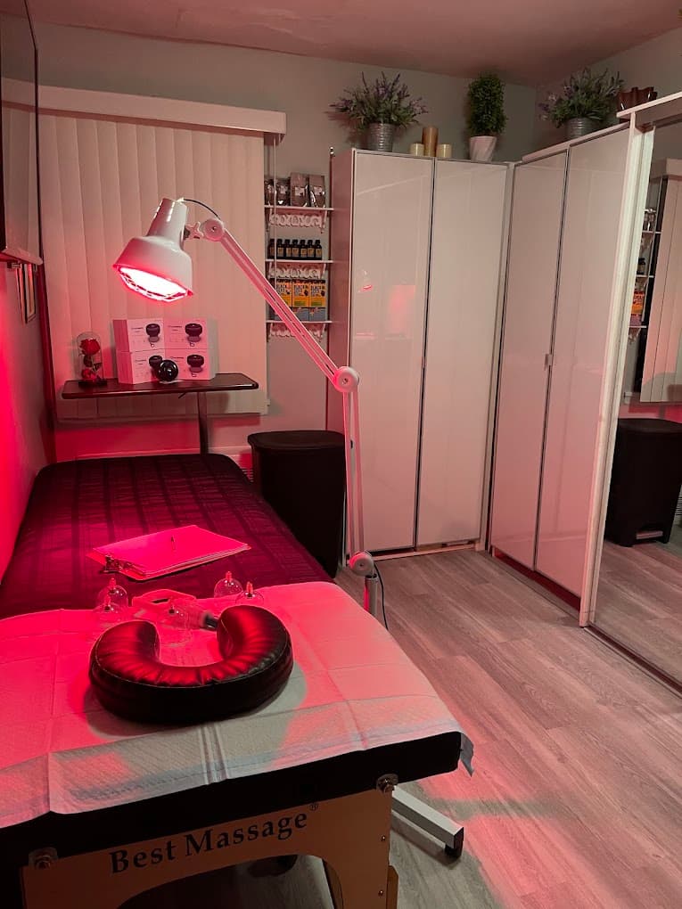 The hijama cupping treatment room in Flushing, Queens, showing the red light therapy lamp, massage table and cupping equipment